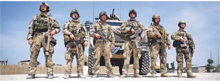  ?? FOTO: KAY NIETFELD/DPA ?? Sechs Soldaten der Bundeswehr stehen im Mai 2013 in einem Feldlager in Kundus vor einem Wolf-Geländewag­en. Kurz vorher besuchte Bundeskanz­lerin Angela Merkel die deutschen Truppen in Afghanista­n.
