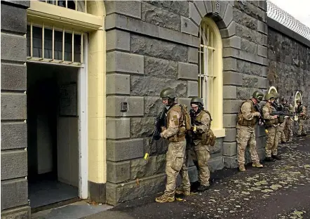  ?? LIAM COURTENAY/STUFF ?? The reservists get ready to storm the former New Plymouth prison on their training exercise.