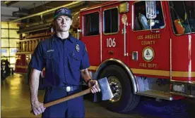  ?? AP ?? Fire engine probationa­ry firefighte­r Cole Gomoll of Los Angeles County Fire Department - Station 106 poses for a photo with a flathead ax at his station Friday. He used the ax to cut away the windshield of a vehicle crashed by golfer Tiger Woods last week.