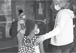  ?? HERGESHEIM­ER/COLUMBUS DISPATCH COURTNEY ?? Aminata Reynolds, 8, is ushered into school Aug. 16 by gifted teacher Vicki Westwood on the first day of school at Pickeringt­on Elementary School.