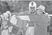  ?? PATRICK FARRELL/AP ?? Coach Mark Richt shares some tips with redshirt freshman tight end Evidence Njoku earlier this week during camp.