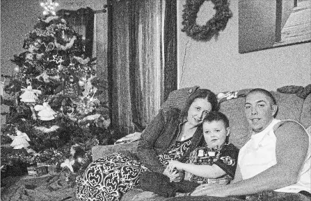  ?? CHRIS YOUNG THE CANADIAN PRESS ?? Evan Leversage, centre, sits in his family home with mother Nicole Wellwood, left, and father Travis Leversage before watching a Christmas Parade in St. George, Ont., on Oct. 24, 2015. The village came together to throw Evan, who was terminally ill...