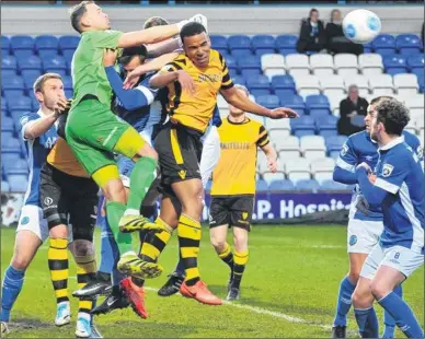  ?? Picture: Steve Terrell ?? Maidstone defender Kevin Lokko challenges as Macclesfie­ld keeper Craig Ross punches clear