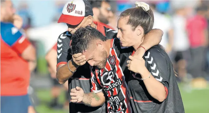  ?? TELAM ?? Barbarie. Facundo Brandán deja el campo de Arsenal acompañado por la médica de Chacarita luego de ser impactado por el botellazo arrojado desde la platea de Tigre.