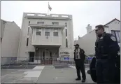  ?? JEFF CHIU — THE ASSOCIATED PRESS ?? A security guard and San Francisco Police Officer stand in front of the entrance to the Consulate General of India in San Francisco on Monday. San Francisco police had erected barriers and parked a vehicle nearby as people protested outside the Consulate General of India to protest the capture of Amritpal Singh.