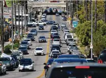  ?? Richard Vogel / Associated Press ?? A line of traffic winds its way along a street near downtown Los Angeles on Sunday. The number of daily passenger vehicle trips recently reached pre-pandemic levels for the first time in a year.