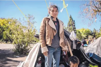  ?? ROBERTO E. ROSALES/JOURNAL ?? A mother from the state of Guerrero stands outside the tent she’s living in with three children. They are camped out in a park near the Bridge of the Americas in Ciudad Juárez with hundreds of other Mexican families who are seeking asylum in the U.S.