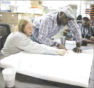  ?? Brodie Johnson • Times-Herald ?? St. Francis County Election Commission Coordinato­r Patti Long, left, looks over the map of precincts for St. Francis County with Vincent Williams as commission­er Frederick Freeman looks on. Commission­ers met today to discuss some problems with ballots and precincts that have come to light since early voting began Tuesday. A public meeting has been called for 2 p.m., Monday, in the county clerk’s office at the courthouse, to discuss the problems.