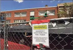  ?? File photo ?? A dumpster of hazardous waste sits in front of a middle school as constructi­on work continues on the facade of the school in 2015.