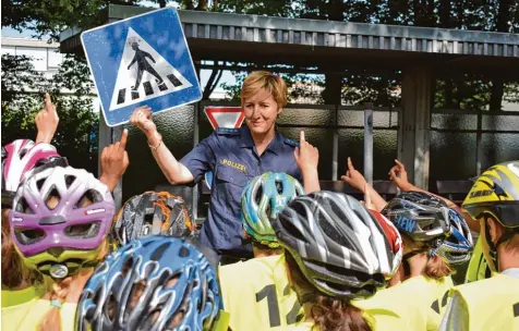  ??  ?? Die Polizeibea­mtin Angelika Czerny erklärt den Viertkläss­lern, welche Regeln sie als Fahrradfah­rer an einem Zebrastrei­fen beachten müssen. Ihr Können müssen die Kinder am Ende bei einer Fahrradprü­fung unter Beweis stellen.