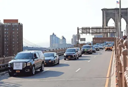  ?? MARK LENNIHAN/AP ?? Uber and Lyft drivers cross the Brooklyn Bridge in a caravan of about 25 vehicles Wednesday in New York City. The protests arrive just ahead of Uber’s initial public stock offering, which is planned for Friday.