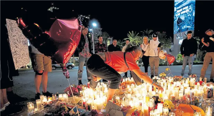  ?? REUTERS ?? Homenaje a las víctimas. En vigilia, habitantes de Las Vegas colocan velas en el sitio de la masacre y donde se realizó el concierto de música country el último sábado.