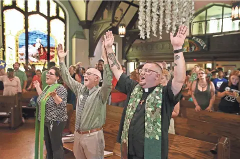  ?? MICHAEL SEARS / MILWAUKEE JOURNAL SENTINEL ?? The Rev. Steve Jerbi (right) raises his hands in praise during a song at All Peoples Church on N. 2nd St. in Milwaukee on Sunday, where Jerbi delivered his last Sunday sermon before moving to another church in Los Angeles. He has been an outspoken...