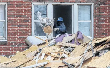  ?? TIM KROCHAK • THE CHRONICLE HERALD ?? A contractor throws garbage onto a pile as the demolition continued at an Oxford Street apartment building in Halifax on Jan. 4.