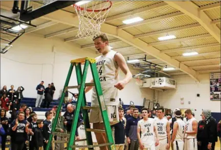  ?? DAVID TURBEN — THE NEWS-HERALD ?? Josh Irwin cuts down the net after West Geauga defeated Beachwood to win the CVC Chagrin title on Feb. 6.