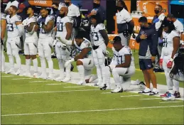  ?? JIM MONE — THE ASSOCIATED PRESS ?? Members of the Titans take part in the national anthem before a game against the Vikings on Sunday in Minneapoli­s. The NFL says the Titans and Vikings are suspending in-person activities after the Titans had three players test positive for the coronaviru­s, along with five other personnel. The league says both clubs are working closely with the NFL and the players’ union on tracing contacts, more testing and monitoring developmen­ts. The Titans are scheduled to host the Steelers on Sunday.