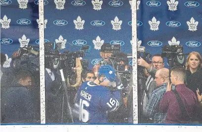  ?? ANDREW FRANCIS WALLACE TORONTO STAR ?? Mitch Marner gets some early practice playing in traffic as he tries to get by a media scrum at the start of Leafs training camp.