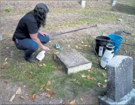  ?? M.E. JONES / LOWELL SUN ?? Cemetery Commission­er Catherine Lahouse cleans off a headstone with an eco-friendly compound.