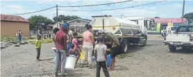  ?? Picture: EDWARD HARKER ?? FILLING UP: Residents get water from a tanker in Timothy Valley. The tanker was later forced to leave the area due to gang violence