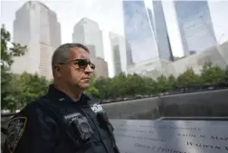  ??  ?? NYPD Officer Michael Dougherty stands beside the south reflecting pool where names of his deceased colleagues and friends are displayed.