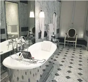  ??  ?? La Reserve is the newest of the palace hotels in Paris. In this suite, the spacious marble bathroom includes a free-standing soaking tub.