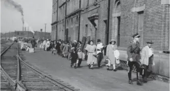  ?? HUKAZAWA EZAKI/NIKKEI NATIONAL MUSEUM ?? People being shipped to Japan are escorted to the immigratio­n building in Vancouver circa 1946. In addition to internment camps, many Japanese Canadians were sent to Japan during the Second World War.