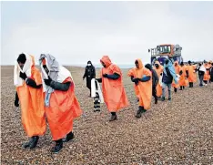  ?? ?? Unsustaina­ble: migrants arrive in Dungeness, Kent, after being rescued by the RNLI