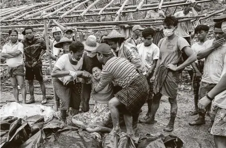  ?? Zaw Moe Htet / Getty Images ?? A woman grieves over the bodies of miners recovered in the jade mining site in Hpakhant, Myanmar. The battered bodies were pulled from a sea of mud after a landslide in one of the worst-ever accidents to hit the nation’s industry.