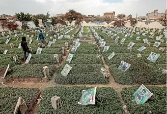  ?? AP ?? Yemeni men mourn among the graves of Houthi fighters at a cemetery in Sanaa yesterday. The war in Yemen has killed some 130,000 people and spawned the world’s worst humanitari­an disaster.