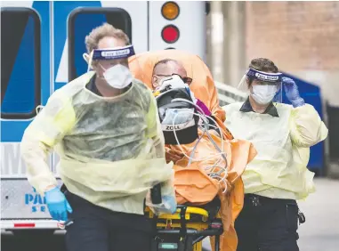  ?? PETER J THOMPSON / NATIONAL POST ?? Paramedics take a patient into Toronto's St. Michael's Hospital in October. Emerging reports indicate that more
patients are surviving severe cases of COVID-19 than was the case during the earlier stages of the pandemic.