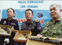  ?? BY ABDUL RAHEMANG TAIMING PIC ?? Eastern Sabah Security Command commander Datuk Hazani Ghazali (centre) with the confiscate­d weapons in Kunak yesterday.