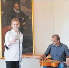  ?? FOTO: MAYER ?? Eva Gentner im Rittersaal vor dem Portrait von Johann Eustach von Westernach bei der Einführung zu ihren Kapfenburg-Geschichts­ergänzunge­n – begleitet an der Gitarre von Claudius Zott.