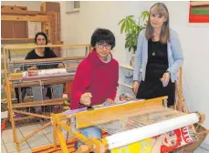  ?? FOTO: SIMON SCHNEIDER ?? Die Praktikant­en Albana Ramadani (hinten) und Sara Sadat Zakizada (vorne) mit Birgit Nesper, Leiterin der Weberei Buntgut.