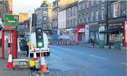  ??  ?? Traffic lights A temporary crossing has been installed. Below, we told you earlier this month how shops were being hit financiall­y by the closure