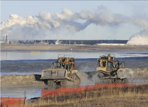  ?? MARK RALSTON/AFP/GETTY IMAGES ?? Workers use heavy machinery in the tailings pond at the Syncrude oilsands extraction facility near Fort McMurray, Alta. A new study suggest that the Alberta oilpatch could make significan­t cuts in methane emissions for very little cost.
