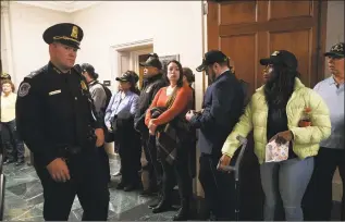  ?? Jacquelyn Martin / Associated Press ?? A U.S. Capitol Police officer walks past veterans with the group “Common Defense,” who said they were “standing in vigil in support of impeachmen­t,” by the hearing room where the House Intelligen­ce Committee was listening to testimony from former White House national security aide Fiona Hill and David Holmes, a U.S. diplomat in Ukraine, on Capitol Hill on Thursday.