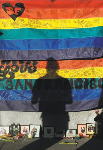  ?? Photos by Scott Strazzante / The Chronicle ?? A shadow is cast on the Orlando massacre memorial at 18th and Castro in San Francisco.