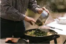  ?? BRETT CARLSEN/THE NEW YORK TIMES ?? Allan Benton, founder of Benton’s Smoky Mountain Country Hams, prepares potatoes with ramps in the Cherokee National Forest in Tennessee. Every spring, Benton heads to the woods to search for alliums and cook up a creekside feast.