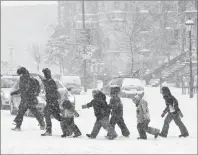 ?? CP PHOTO ?? Children from a daycare centre cross a street during a winter storm in Montreal in 2011.