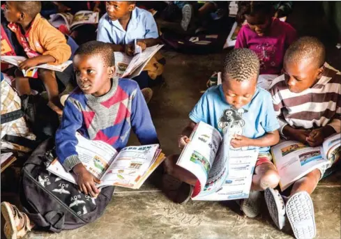  ?? MAURO VOMBE/AFP ?? Pupils attend a primary school where younger grades are taught bilingual classes on June 20 in Manhica, Mozambique.