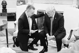  ?? MARK WILSON GETTY IMAGES ?? Donald Trump and U.S. evangelica­l preacher Andrew Brunson, left, participat­e in a prayer in the Oval Office a day after Brunson was released from a Turkish jail.