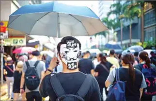  ??  ?? A protester wears a Guy Fawkes mask on the back of his head, popularise­d by the comic book film, in Hong Kong on Tuesday.