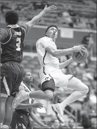  ?? Arkansas Democrat-Gazette/THOMAS METTHE ?? UALR’s Camron Reedus (11) goes up for a shot while being defended by Texas State’s Deris Duncan (3) during the second half of the Trojans’ 72-70 loss Saturday at the Jack Stephens Center in Little Rock.