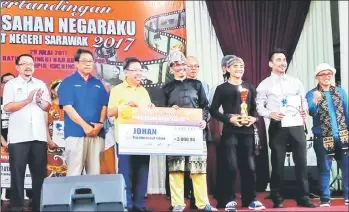  ??  ?? Dr Sim (third left) presents the mock cheque to a representa­tive of the champion team ‘Nurani Poliku’. Abang Sardon is at second left.