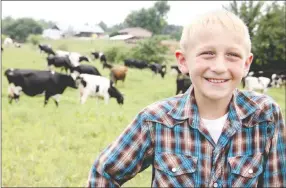  ??  ?? Levi Weaver, 10, talks to the media about working on the dairy farm and caring for his own animals to show at the Washington County Fair. He has been showing animals since he was 3 years old.