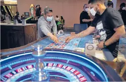  ?? JOHN LOCHER/AP2020 ?? Gamblers wear face masks at the Strat hotel-casino in Las Vegas. Some casinos opened fully this week based on the percentage of employees vaccinated.