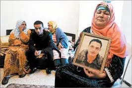  ?? MOHAMED MESSARA/EPA ?? Nour El Houda Hassani 65, holds a portrait of her son, Anis Amri, the suspect in the attack.