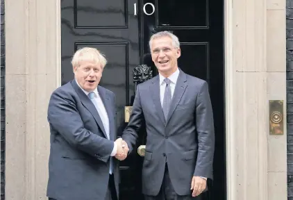  ??  ?? British Prime Minister Boris Johnson greets Nato Secretary general Jens Stoltenber­g, right, before their meeting at 10 Downing Street in London on Tuesday.