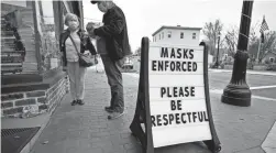  ?? ROBERT F. BUKATY/AP ?? Shoppers comply with the mask regulation­s in Bridgton, Maine, Friday as the state reported a new record number of COVID-19 cases.