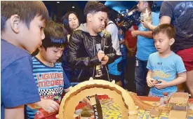  ??  ?? Child star Alonzo Muhlach (center) playing with other young guests at the Gateway Cineplex 10 lobby during the red-carpet screening of Cars 3